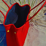 Opened view of red Oaxaca handbag on the sand